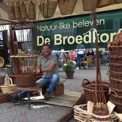 Ambachtelijke demonstratie mandenvlechten De Broedkorf in Oudewater, Groene Hart, vakman maakt rieten manden met wilgentakken op markt met natuurlijke materialen en handgemaakt vlechtwerk.