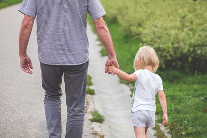 opa met kleinkind aan het wandelen hand in hand