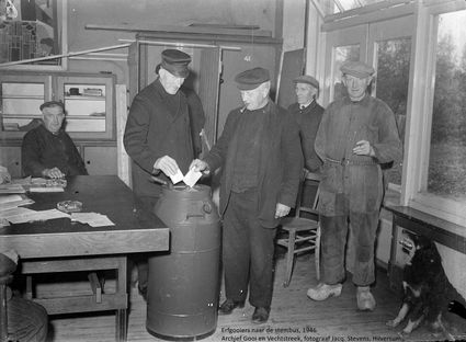Zwart wit foto uit 1946, waarop Erfgooiers te zien zijn die hun stem in een melkbus stoppen.