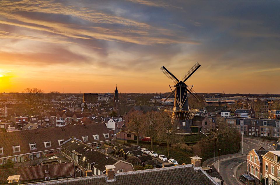Historische stellingmolen De Windhond in Woerden, Groene Hart, met uitzicht over de stad tijdens een kleurrijke zonsondergang. Foto: René Vaillant.