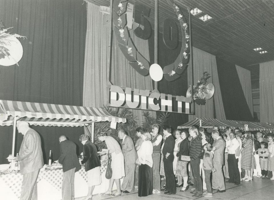 Buffet in de Triantha-hal aan het Stadsbroek na afloop van de prijsuitreiking van de TT-races aan De Haar te Assen. De man in grijs kostuum achter het jongetje midden in de rij is bestuurslid Johan Wagenaar.