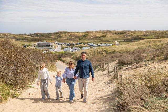 Een gezin loopt het duin op richting zee in Katwijk, met op de achtergrond Strandcamping Zuidduinen in beeld.