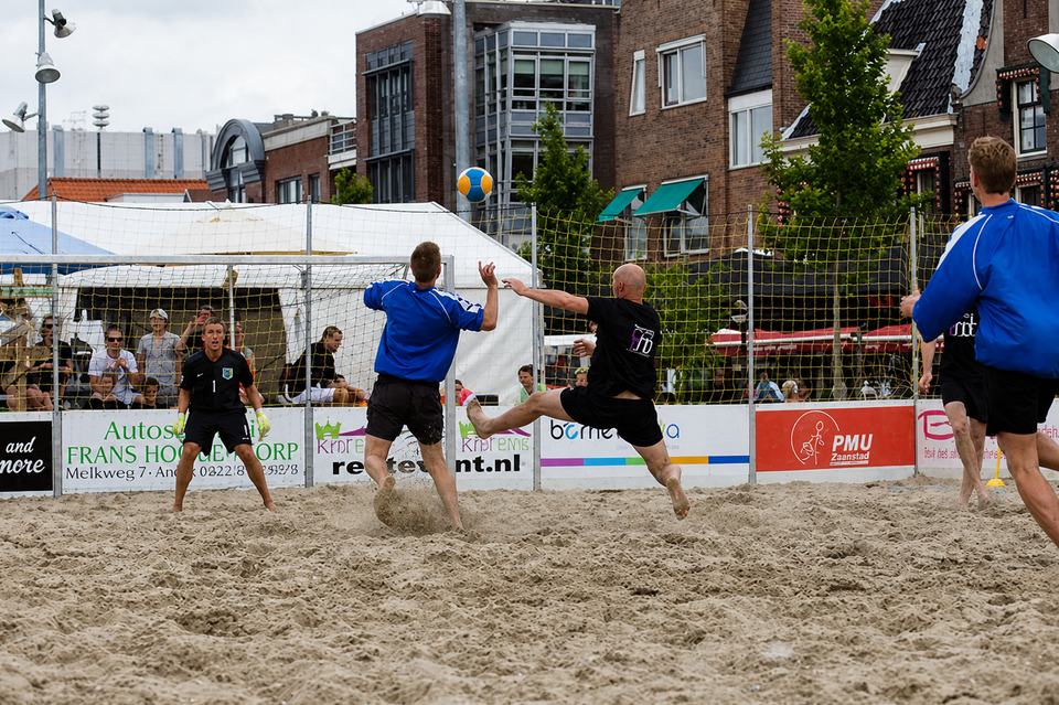 Mensen die aan het voetballen zijn op het strand
