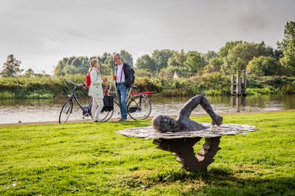 Fietsers bij het standbeeld voor Maarten van der Weijden in Birdaard