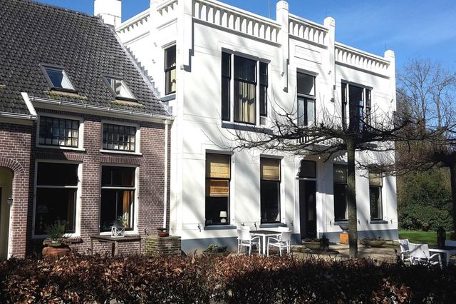 Een deel van een landhuis met een terras.