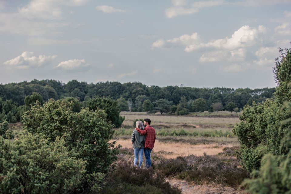 Bei einem Wanderung blickt ein Paar über die 
weite landschaft von Drenthe.