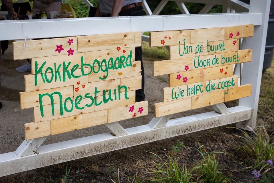 Op de foto zie je een houten bord met daarop vrolijk 'moestuin kokkebogaard' geschreven