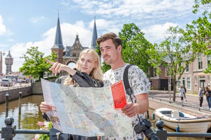 Twee personen lezen de Friesland Regiokaart voor de waterpoort in Sneek.