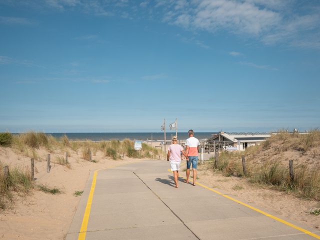 Foto van wandelaars richting een strandpaviljoen in Katwijk aan Zee, in de Streek van Verrassingen.