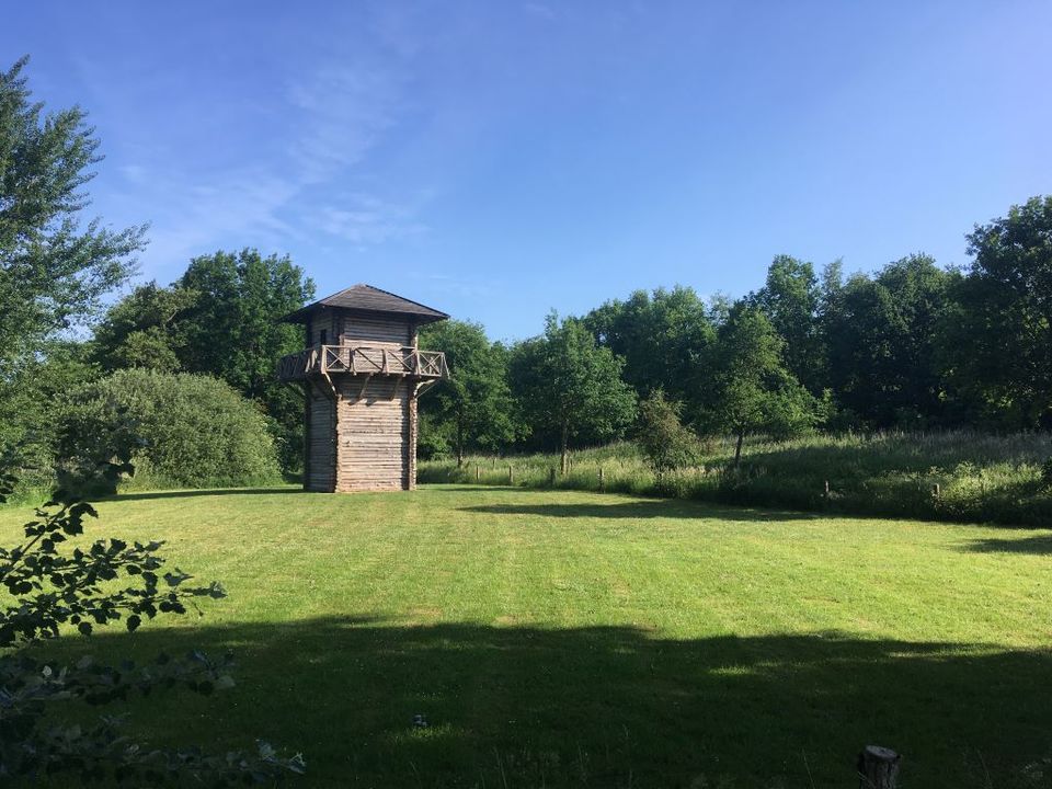 Een houten wachttoren in het groene landschap