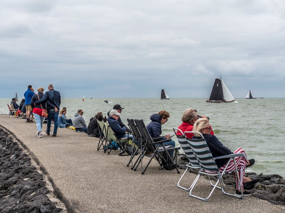 toeschouwers van het skûtsjesilen zitten langs het water