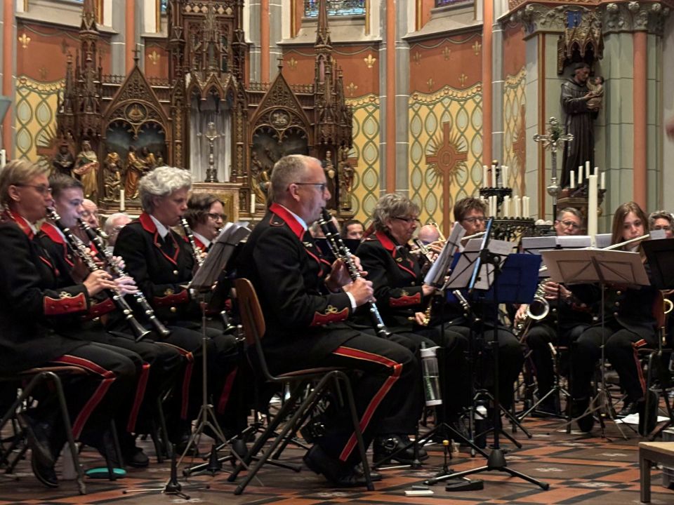 Benefietconcert van muziekvereniging De Vriendschap voor De Mantelmeeuw in Woerden, Groene Hart, met harmonieorkest tijdens een optreden in een kerk.