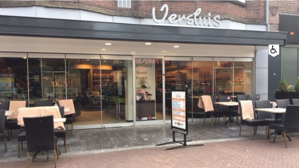 Speciaalzaak Bakkerij Versluis Woerden, provincie Utrecht, Groene Hart, winkelpand met glazen pui en terras aan de Voorstraat in het centrum, bekend om vers brood en banket.