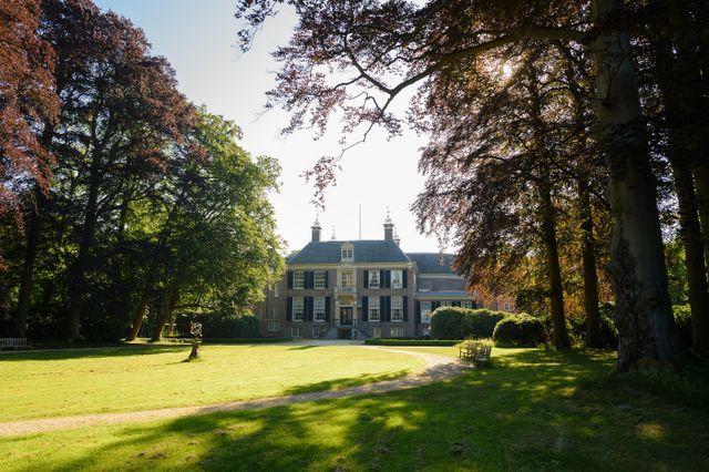 Het vooraanzicht van Kasteel Groeneveld en het bos er omheen in herfstkleuren
