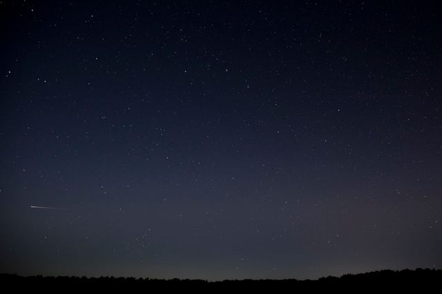 De sterrenhemel in Drenthe met vallende ster.