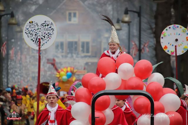 Wagen met Kinder Raad van Elf. Deze zijn in rood wit gekleed en omringd door rood en witte ballonnen