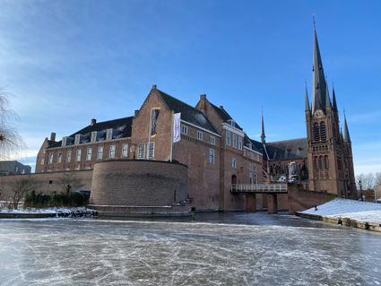 Een prachtig winters tafereel van Kasteel Woerden, waar het eeuwenoude gebouw uitkijkt over een bevroren kasteelgracht vol schaatskrassen. De strakblauwe lucht, de koude helderheid en het contrast tussen ijs en baksteen geven het historische kasteel een indrukwekkende, bijna koninklijke uitstraling in de winterzon.