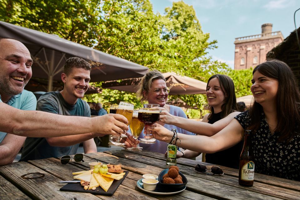 Een groep mensen die gezellig aan het eten en drinken is bij de brouwerij van La Trappe.