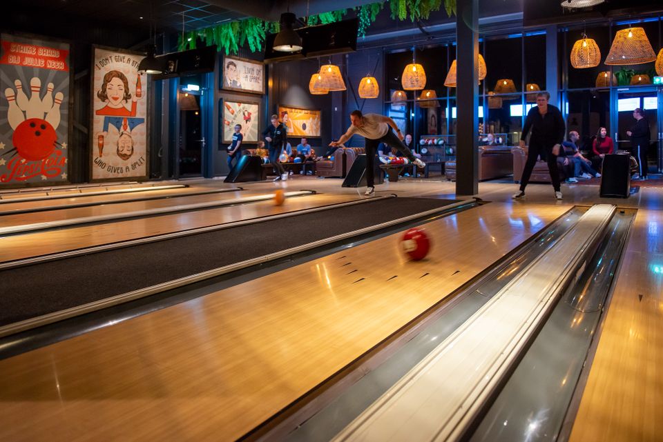 Bowlingbanen in Posta7 in Tolbert, met sfeerverlichting en eigen scoreschermen.