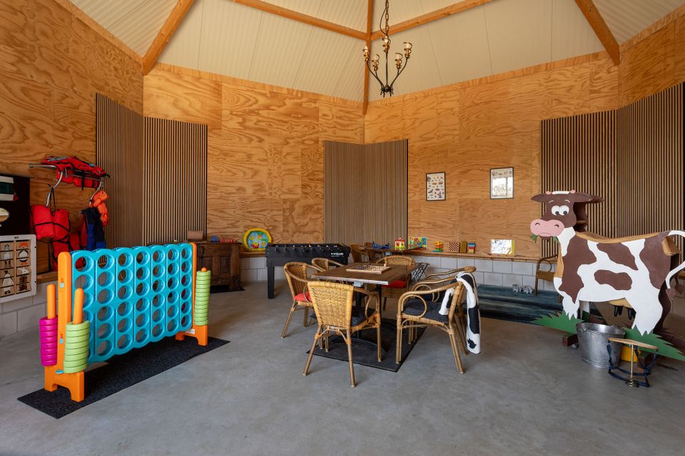 Bed & Breakfast Hazenveld in het Groene Hart, overdekte speelruimte met grote vier-op-een-rij, tafelvoetbal, gezelschapsspellen, zitplaatsen en een houten koe voor kinderen.