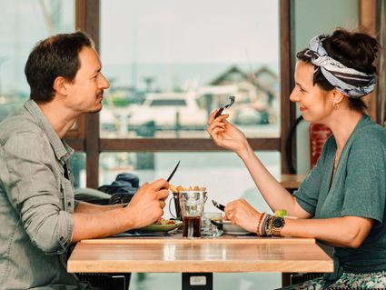 Man en vrouw aan het dineren in restaurant in haven.