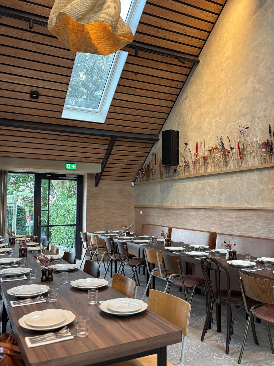 Feest- en vergaderlocatie De Deel bij Restaurant De Oortjeshoeve in Kamerik, Groene Hart. Sfeervolle zaal met lange tafels, houten plafond, dakraam en landelijke inrichting voor groepen en bijeenkomsten.