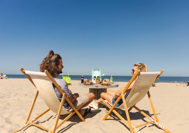 man en vrouw in strandstoel kijkend naar de zee