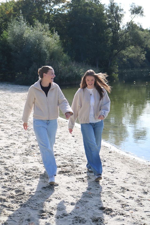 twee vrouwen wandelen op strand