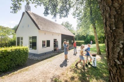Gezin dat een kijkje neemt bij het Koloniehuisje in Frederiksoord