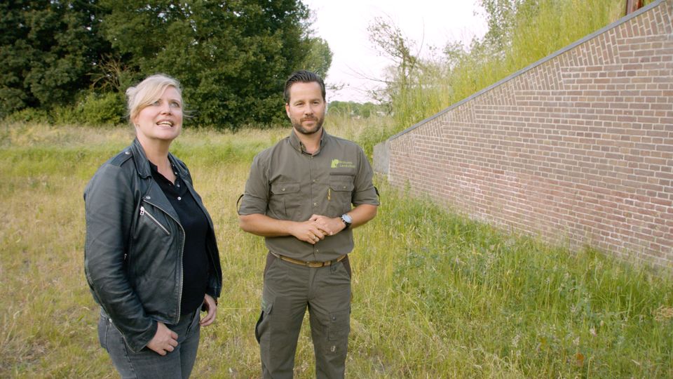 Een man en een vrouw staan naast elkaar in een groene omgeving