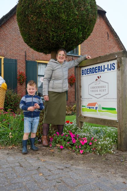 Een vrouw en een kind staan voor een ijsboerderij.