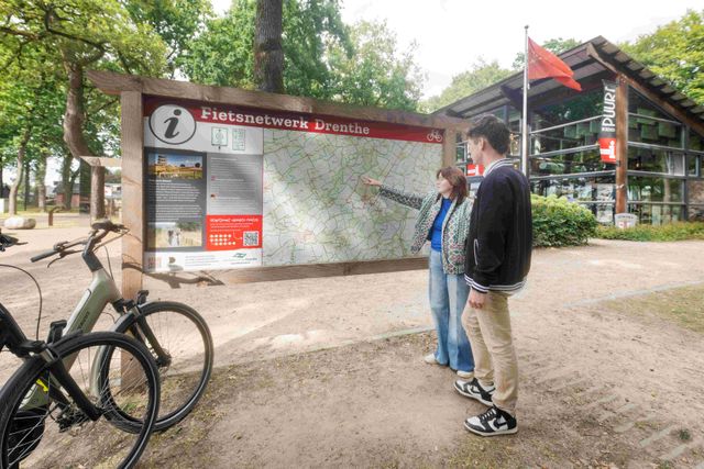 Jong stel staat bij fietsnetwerk bord in Diever.