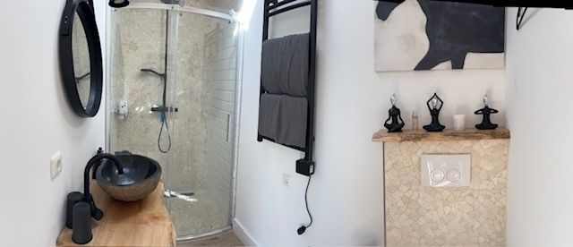 Moderne badkamer met natuurstenen wastafel, glazen douche en strak design