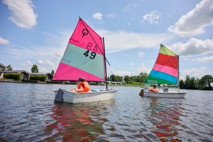 Twee kinderen die zeilen in een een optimist op het Nannewiid.