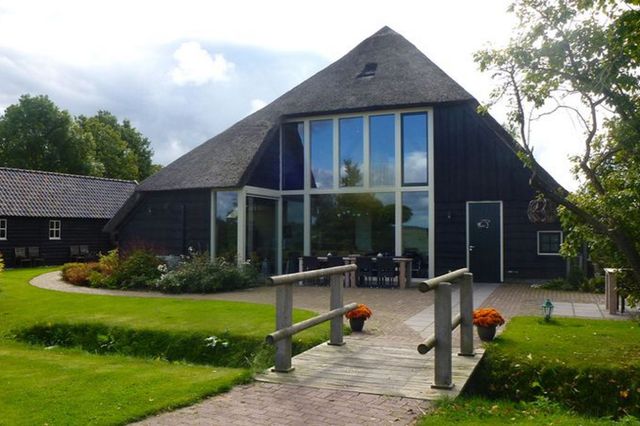 Een grote boerderij waarin een groepsaccommodatie gevestigd is.
