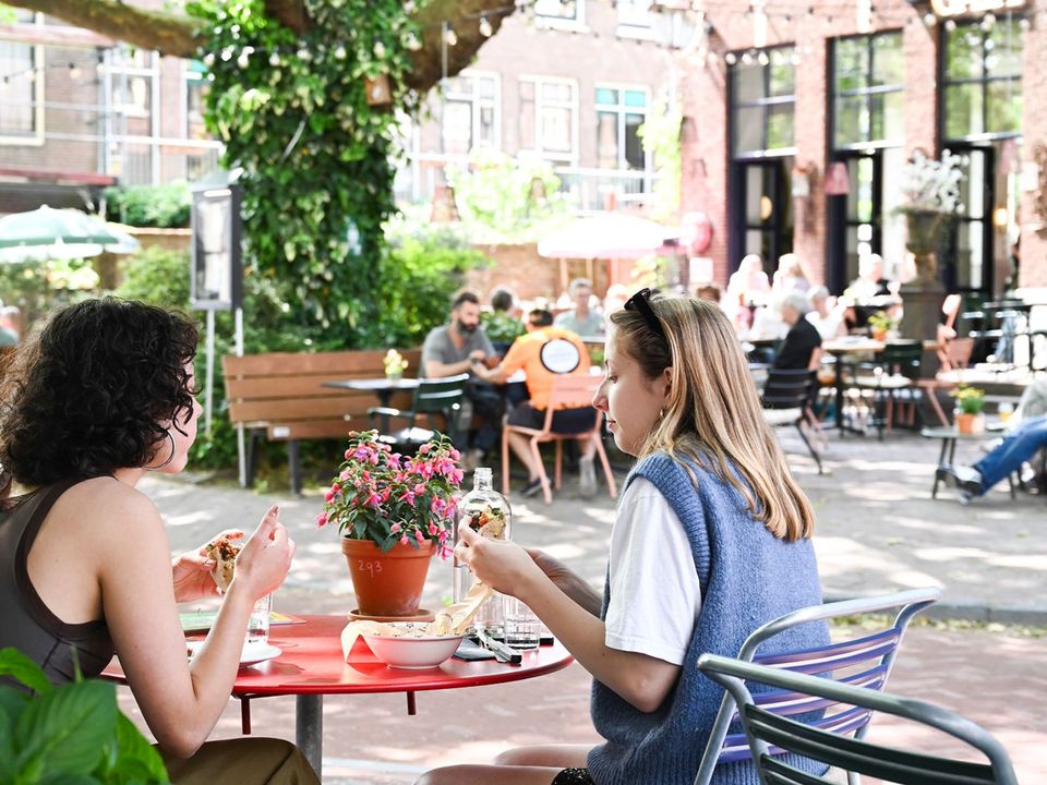 Twee meiden die dineren op het Doelenplein in Delft