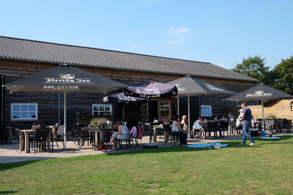Zonnig terras met parasols bij de Kinderspeelboerderij De Gerrithoeve in Oisterwijk.