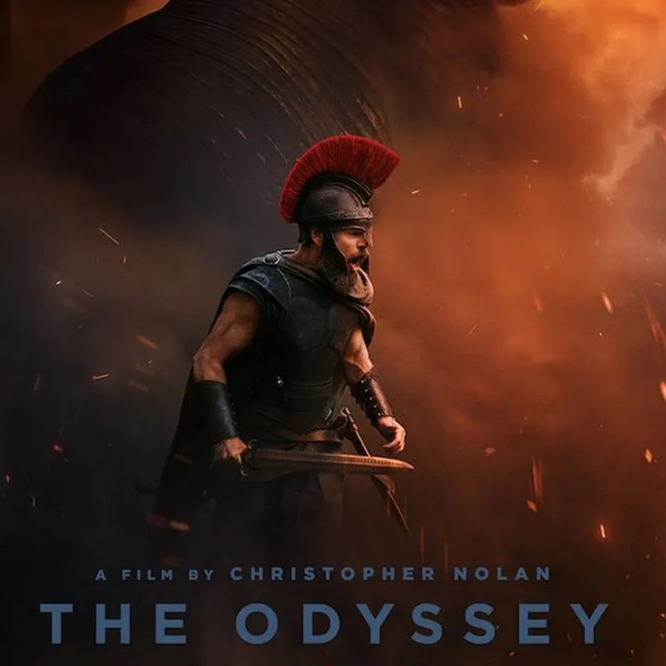 Een strijder in harnas met een helm op, deze helm heeft een rode hanenkam. Hij heeft een zwaard in de hand. De achtergrond is oranje-rood.
