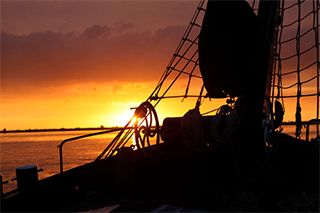 Zeilvloot met zonsondergang