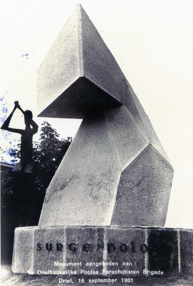 In 1961 verrees het huidige monument. Hier op een foto uit die tijd, nog omgeven door groen en op de achtergrond is nog net het parochiehuis te herkennen.