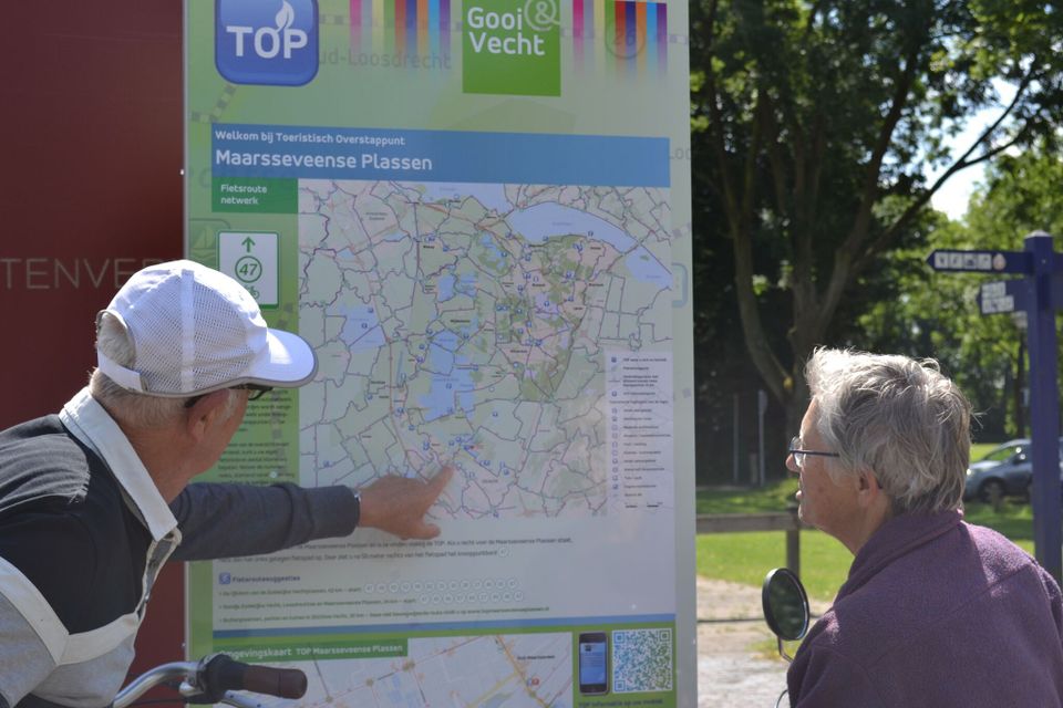 Fietsers stappen af om het informatiepaneel bij Maarsseveense Plassen te bekijken