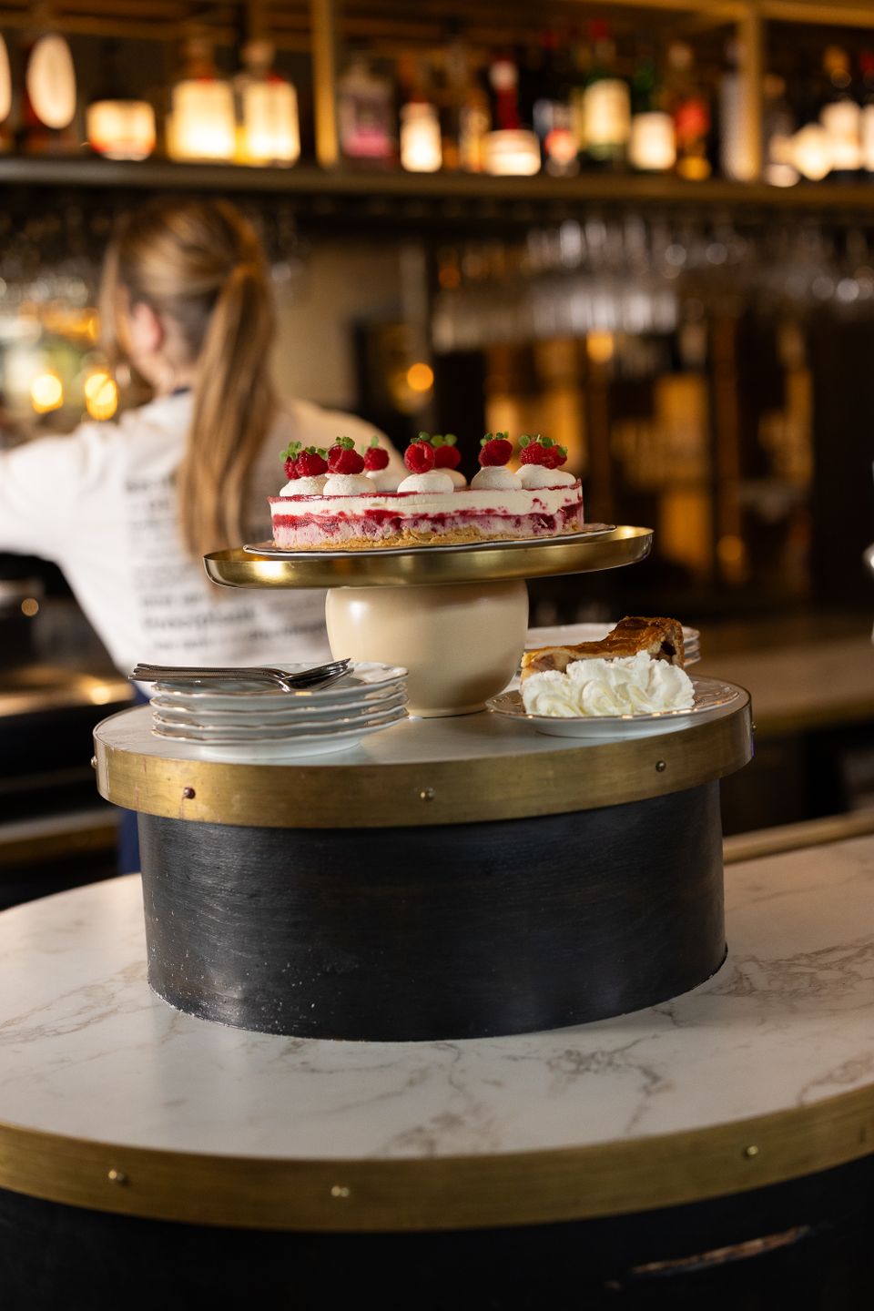 Restaurant Bistro de Bock in Woerden, Groene Hart, sfeervolle horecalocatie met stuk frambozentaart en slagroom op een serveertafel in een warme baromgeving.