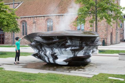 Kind staat bij de ijsfontein in Dokkum waar damp vanaf komt en ijs op zit