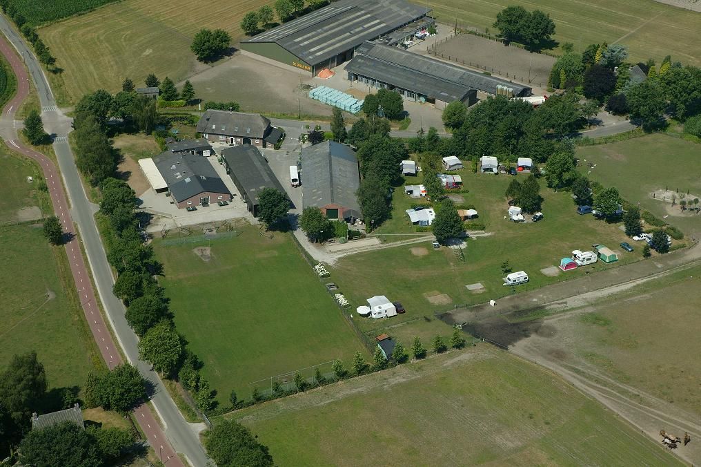 Luchtfoto met overzicht van de kampeerboerderij en kampeerplaatsen in het groen.