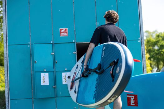 Jongen pakt SUP-board uit de verhuurbox.