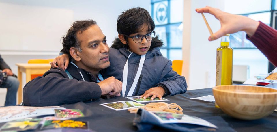 Jongen en vader kijken samen naar een experiment tijdens science day