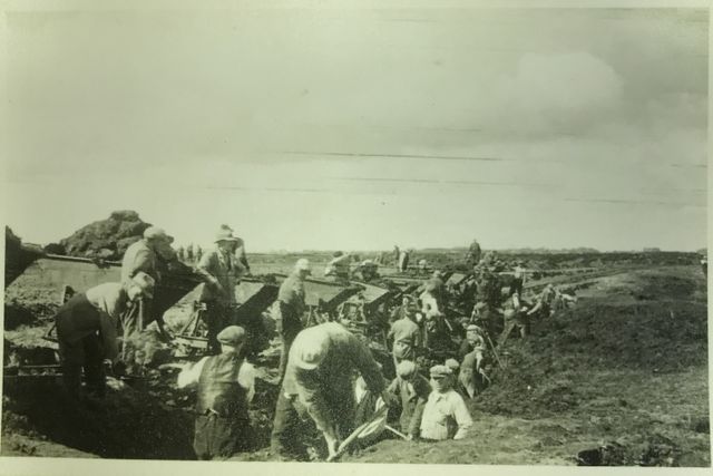 Arbeiders bezig met de aanleg van een van de startbanen van vliegveld Peest, met behulp van kiepkarren.