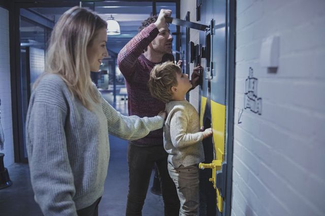Ein Junge schaut mit seinen Eltern durch eine Zellentür im Nationaal Gevangenismuseum in den Niederlanden.