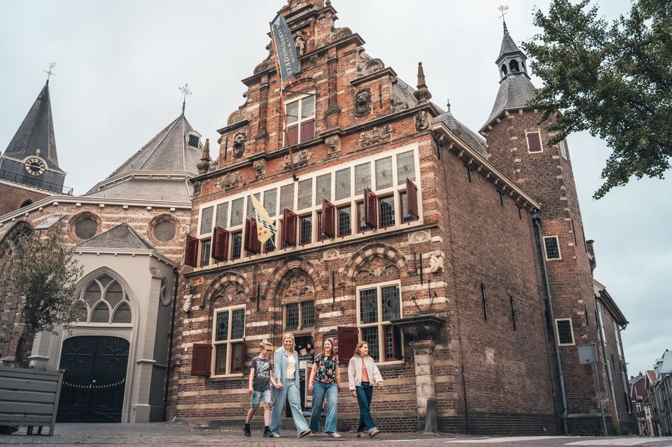 Historisch museum Stadsmuseum Woerden, Groene Hart, met wandelende bezoekers voor het monumentale voormalige stadhuis in de binnenstad.
