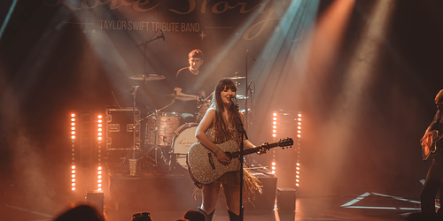Een foto van een vrouw die aan het zingen is met gitaar